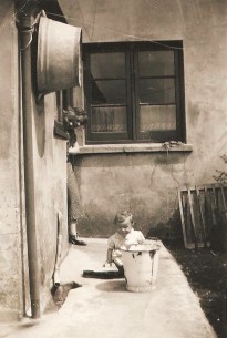 My own mother playing, during the 1930s, in the space between the back door and the toilet.  It looked exactly like that when I was a little girl.